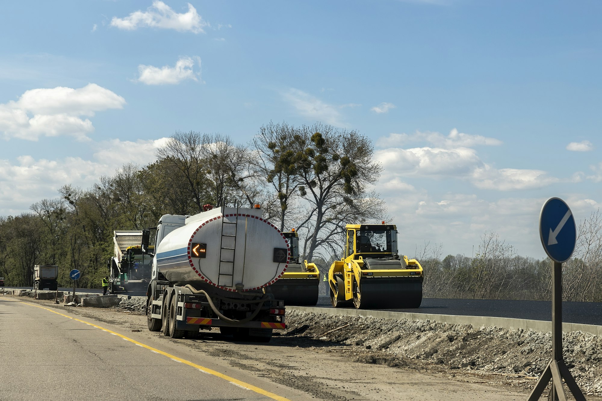 Highway intercity new road construction site with many heavy machinery steamroller, water tanker