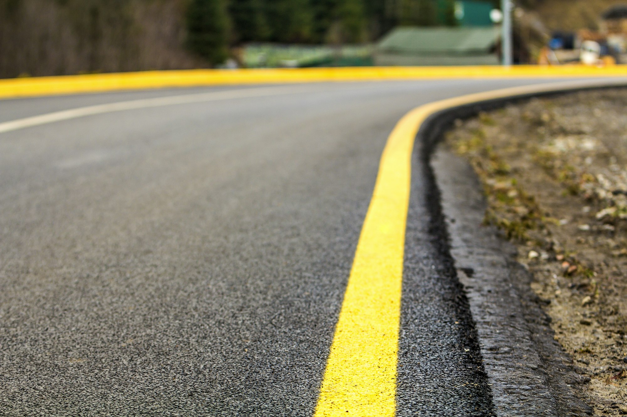 Perspective of asphalt road with yellow line on it